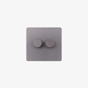 Korix Double Light Dimmer – Grey Product Description The Korix Double Light Dimmer combines two independent rotary controls on a single wall plate. Users can adjust two separate lighting circuits from one convenient location while keeping the electrical layout clean and compact. Its grey finish, rounded corners and matching circular controls suit contemporary residential, hospitality and commercial interiors. The simple design also works well in projects where electrical accessories need to blend naturally with the surrounding interior. Double Light Dimmer for Two Lighting Zones Two rotary knobs provide independent control of separate lighting circuits. For example, one control can manage the main ceiling lights while the other adjusts accent, decorative or secondary lighting. This arrangement works particularly well with layered lighting schemes because users can set different brightness levels for different functions. Combining both controls on one plate also reduces the need for separate wall accessories. Independent Rotary Adjustment Each knob gives the user direct manual control over its connected circuit. Brighter settings can support reading, working or general activities. Alternatively, users can reduce the illumination level to create a softer atmosphere for relaxing, dining or evening use. The rotary interface keeps operation straightforward and familiar. In addition, the two controls remain clearly separated, making it easy to identify and adjust each lighting zone independently. Minimal Grey Finish A neutral grey finish covers both the wall plate and controls. The matching components create a coordinated appearance, while the rounded rectangular plate keeps the overall design understated. This dual rotary dimmer can pair naturally with modern furniture, neutral wall finishes and contemporary electrical accessories. Two-Zone Lighting Control for Modern Interiors The unit suits bedrooms, living rooms, dining areas, hotel rooms, offices and meeting spaces. Designers can use the two channels to separate general lighting from accent or decorative illumination. For example, one circuit might operate recessed ceiling lights while the second controls a pendant, wall light or other secondary lighting layer. This approach gives users greater control over the lighting atmosphere without adding extra wall plates. Technical Specifications Parameter Specification Product Type Dual Rotary Light Dimmer Number of Controls 2 Control Method Rotary Lighting Zones 2 Colour Grey Installation Wall Mounted / Recessed Application Interior Lighting Control
